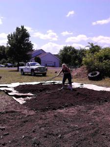 Me spreading compost on the second layer. Wood chip mulch tops it off.